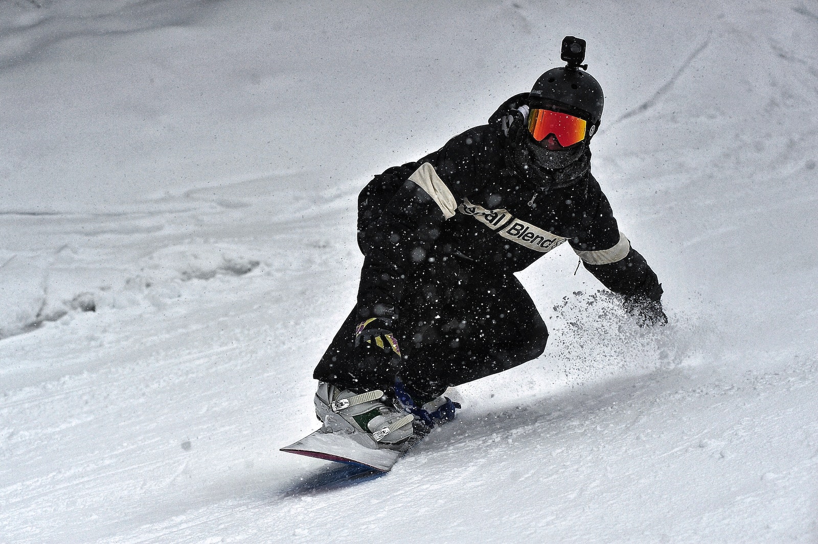 Person in Black Jacket and Black Pants Riding on Snowboard